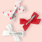 Upcycled Mayvis Mini bow set in Coral Swiss Dot series on alligator clips back view